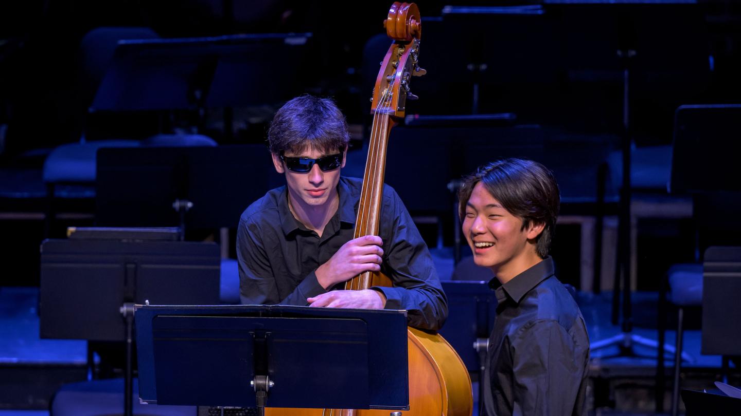 Two students on stage during orchestra rehearsal