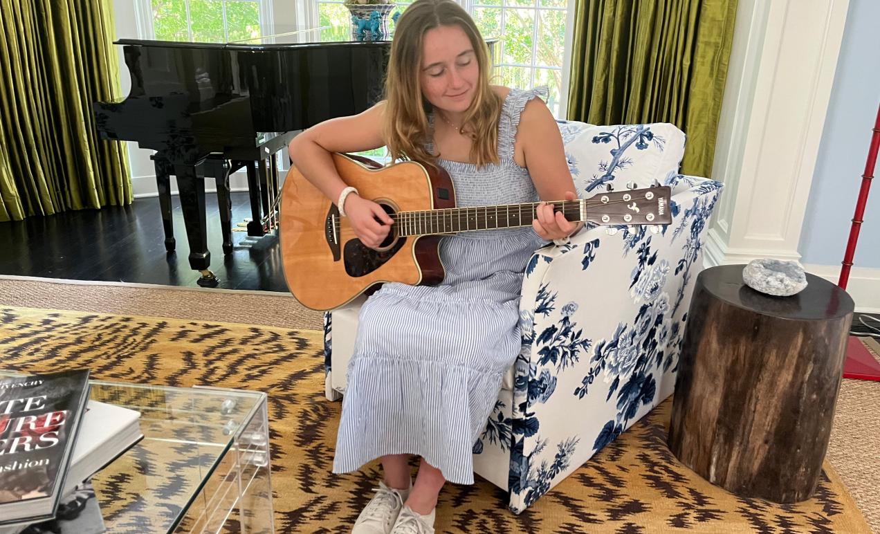 Olivia Connolly playing her guitar