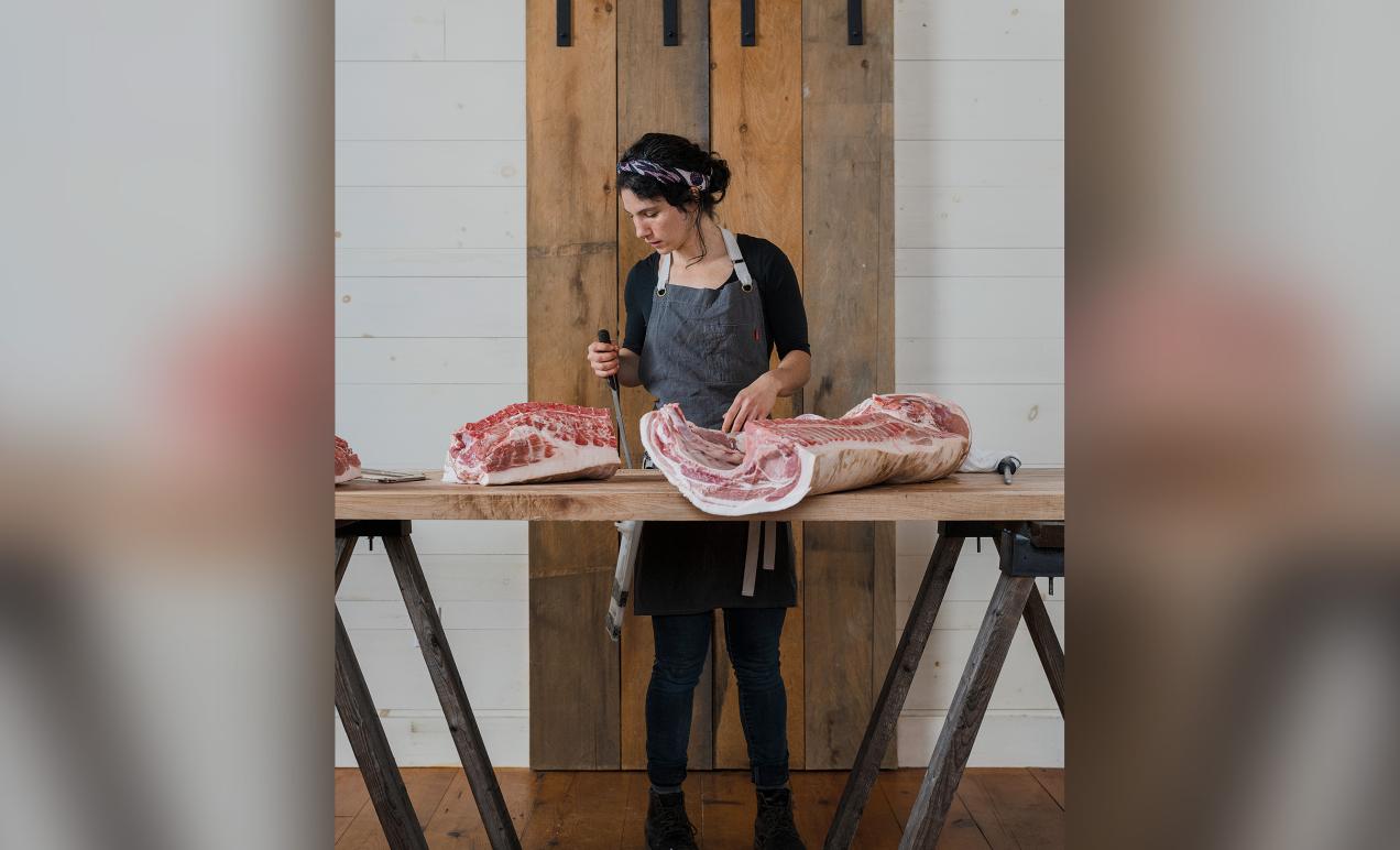 Anna Hymanson ’12 in her element as manager of the butcher shop and local foods market at The Rooting Pig at Broad Arrow Farm in Bristol, Maine.