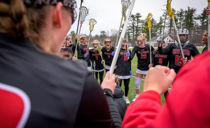 girls varsity lacrosse huddle before their game against Exeter.