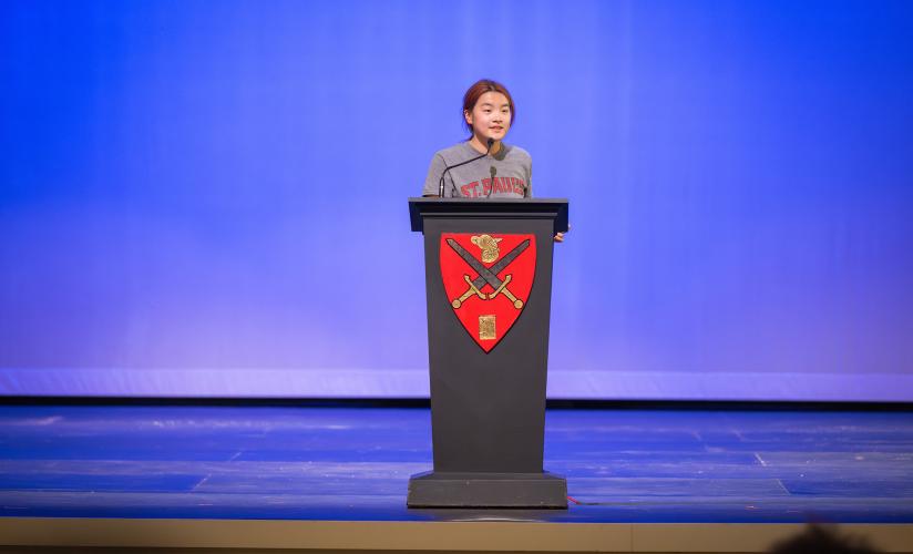 Alice Qi '28 on stage in Memorial Hall during the annual Hugh Camp Cup speaking competition.