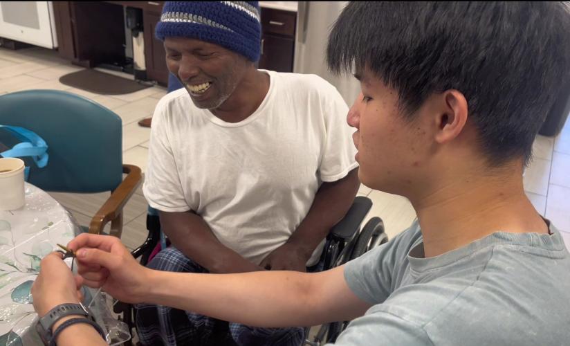William Su teaching Mr. Deki to knit