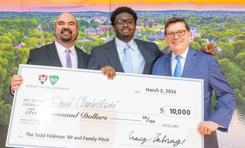 David "Duke" Charles II '23 holds his check with Director of the Bozzuto Center Craig Talmage and President Mark D. Gearan at Hobart and William Smith..