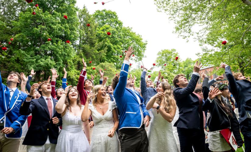 Graduates toss their roses in the air at the conclusion of the Graduation Ceremony