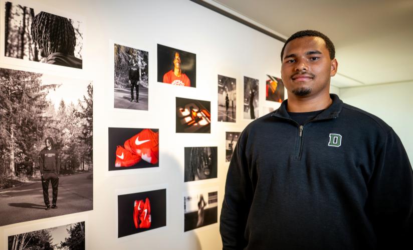 Harlem Taylor '26 stands infront of his photos at an exhibit in the Crumpacker Gallery.