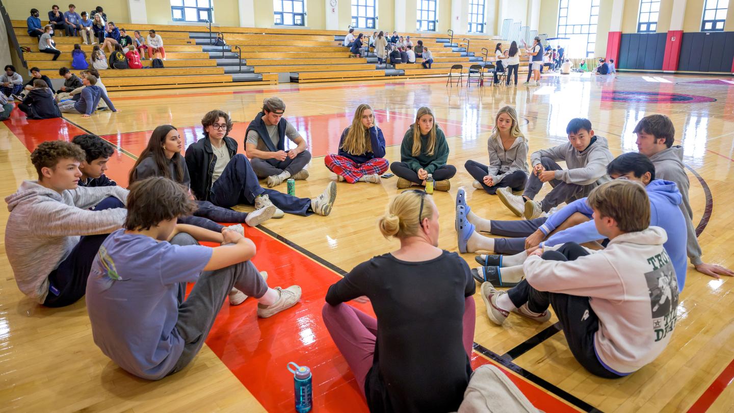 students and faculty in a circle for LinC Day. 