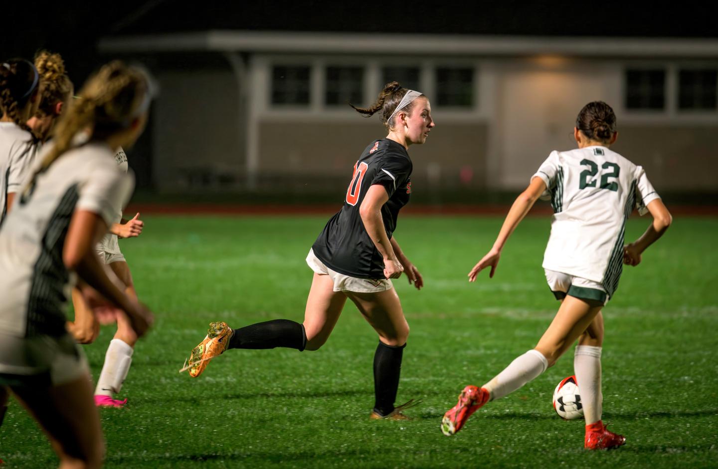 Georgia Bussey '24 takes the ball up the field in SPS Girls Varsity Soccer's game against Deerfield Academy during a special home night game in October, 2023.