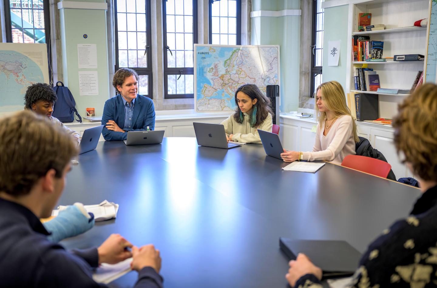 Humanities teacher and chaplain Rev. Sam Lovett leads a discussion in his Science, Philosophy and Religion class around the Harkness Table.