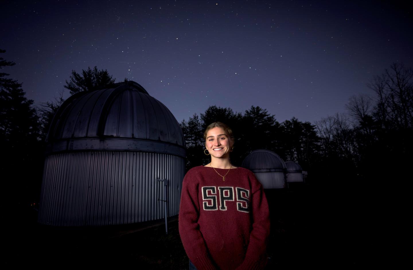 Emmerson Bentley '25, stands infront of the Hawley Observatory at SPS, where she spends much of her time looking at the stars.