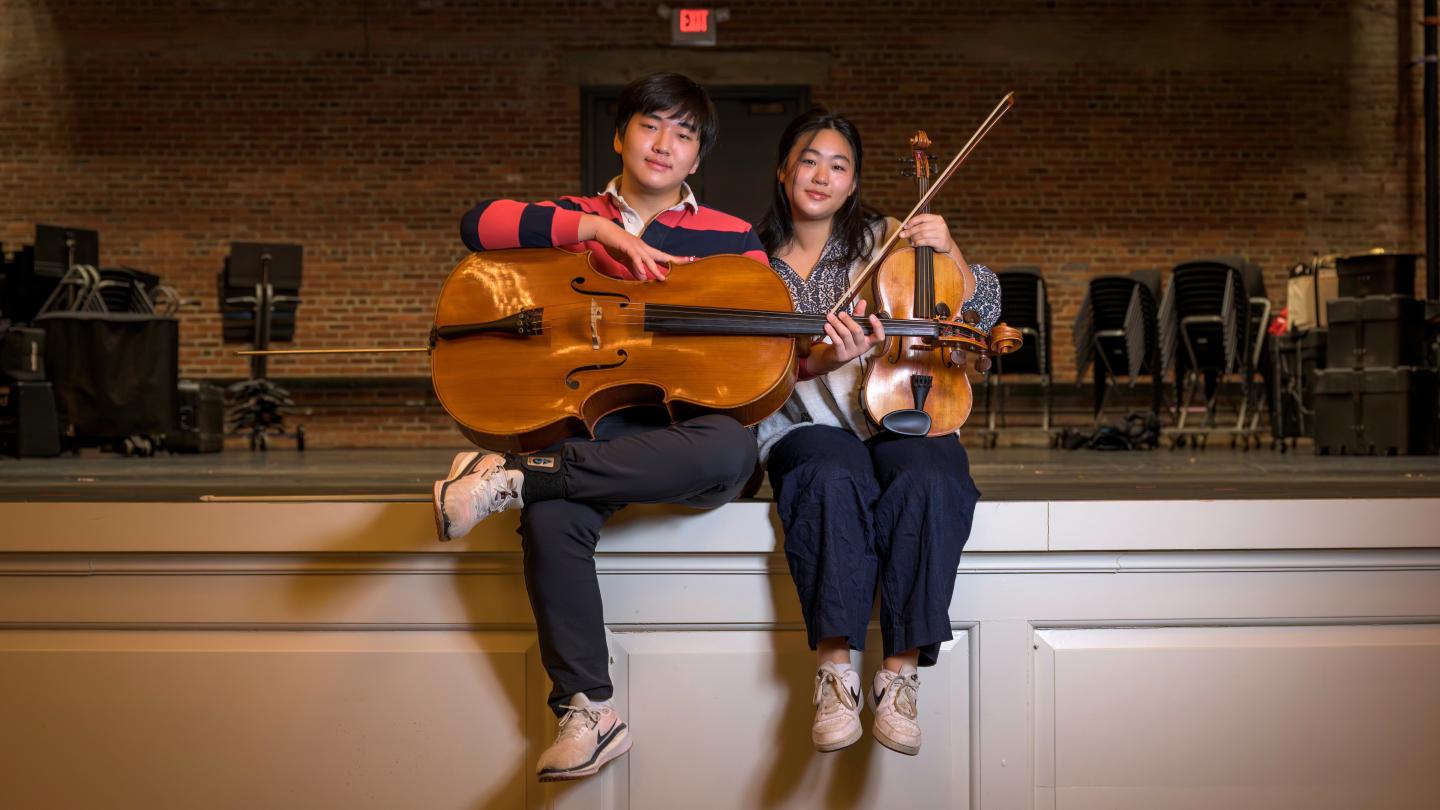Ian '26 and Hana '27 pose together on the stage in Memorial Hall days before playing together in the annual Winter Concert.