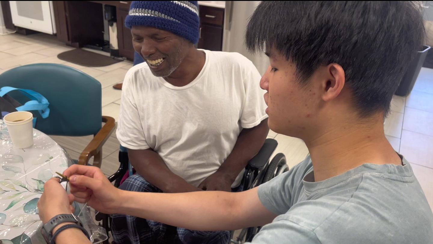 William Su teaching Mr. Deki to knit
