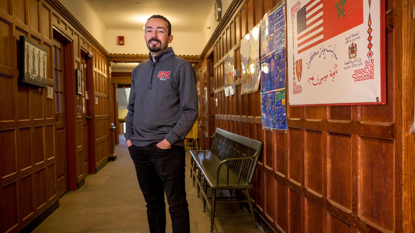 Environmental portrait of Zayer Baazaoui in the hallway of the Schoolhouse