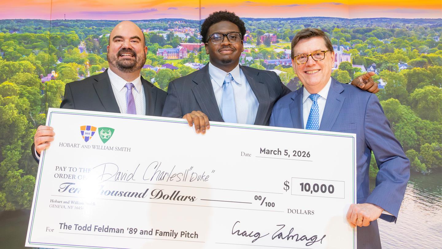David "Duke" Charles II '23 holds his check with Director of the Bozzuto Center Craig Talmage and President Mark D. Gearan at Hobart and William Smith..