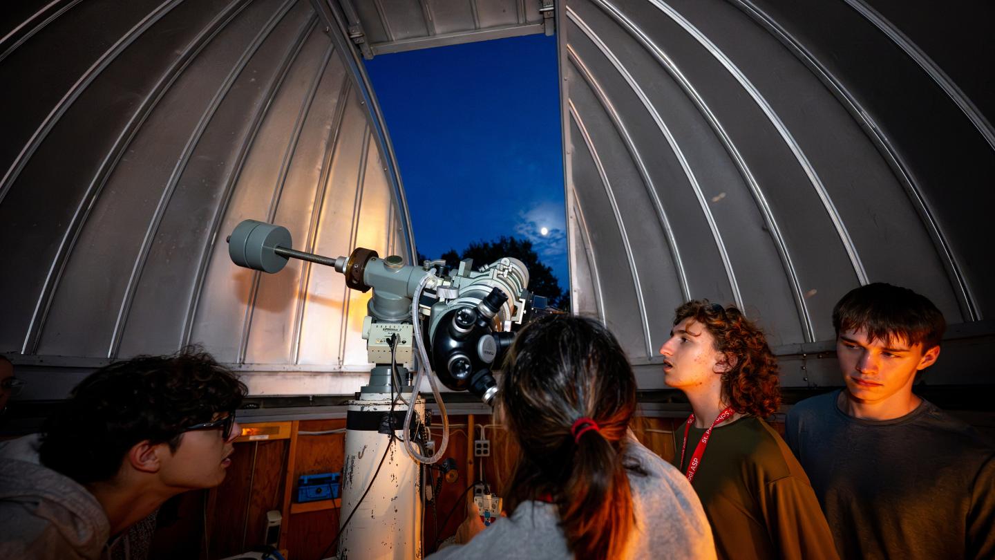Students gather around one of the reflecting telescopes at the School’s Walter and Lenore Hawley Observatory.