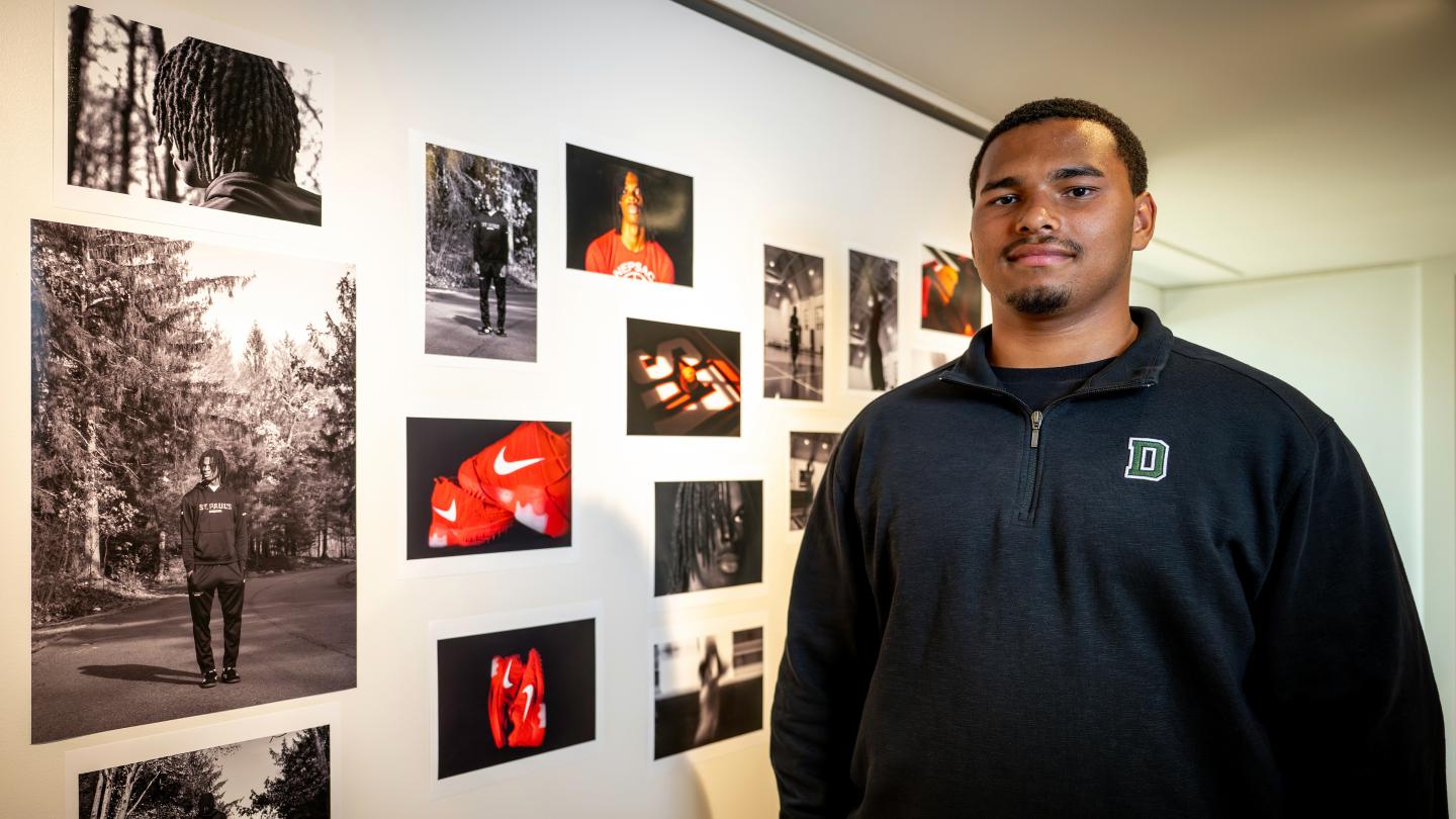 Harlem Taylor '26 stands infront of his photos at an exhibit in the Crumpacker Gallery.