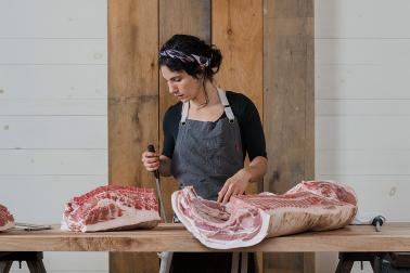 Anna Hymanson '12 working at a butcher shop